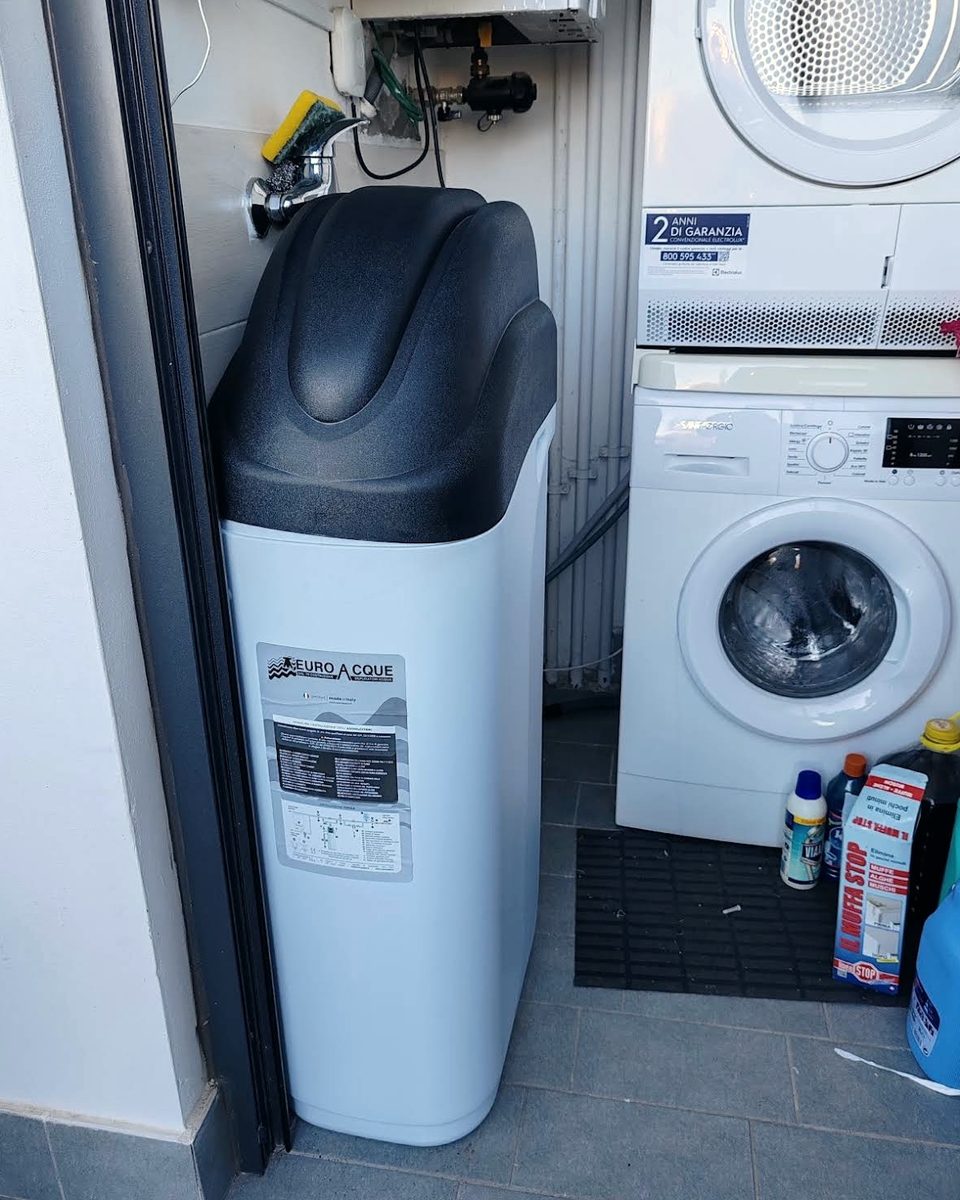 Addolcitore installato in una lavanderia accanto alla lavatrice