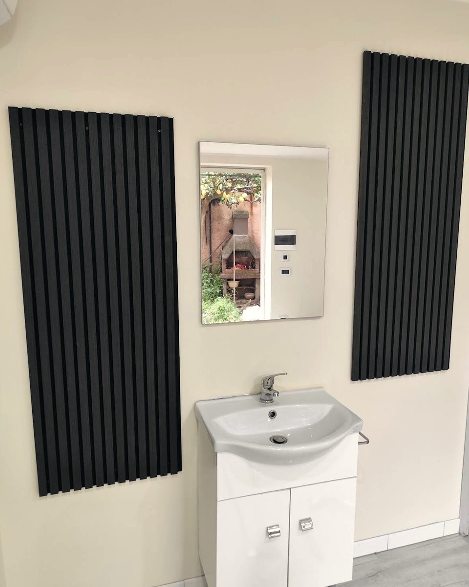 Bagno con mobile lavabo bianco e due termoarredi neri