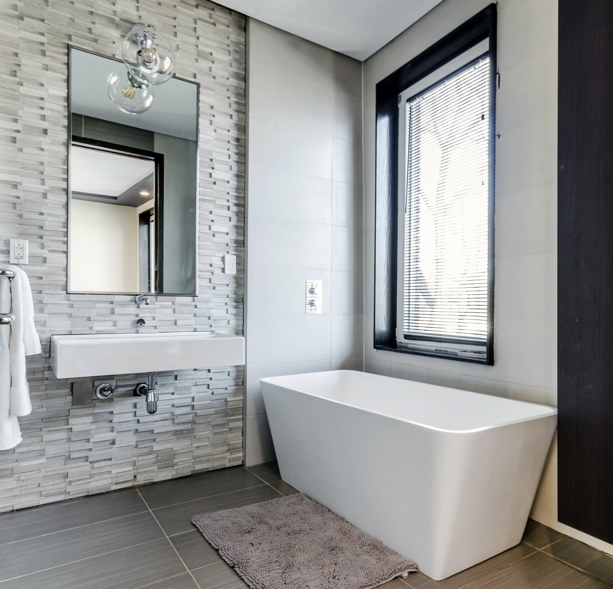 Bagno con vasca e parete in pietra chiara