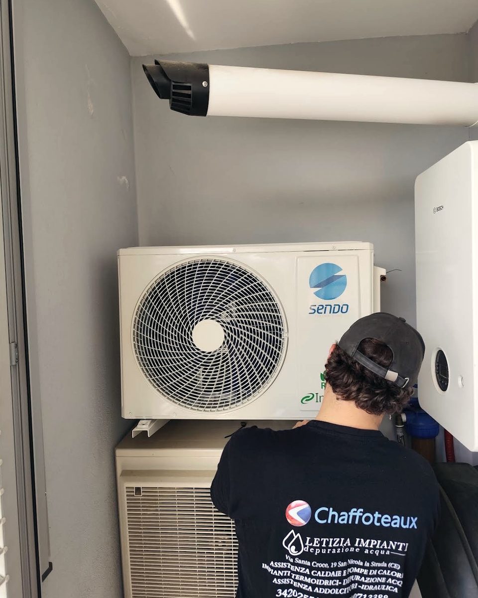 Tecnico al lavoro su un climatizzatore installato in un vano tecnico