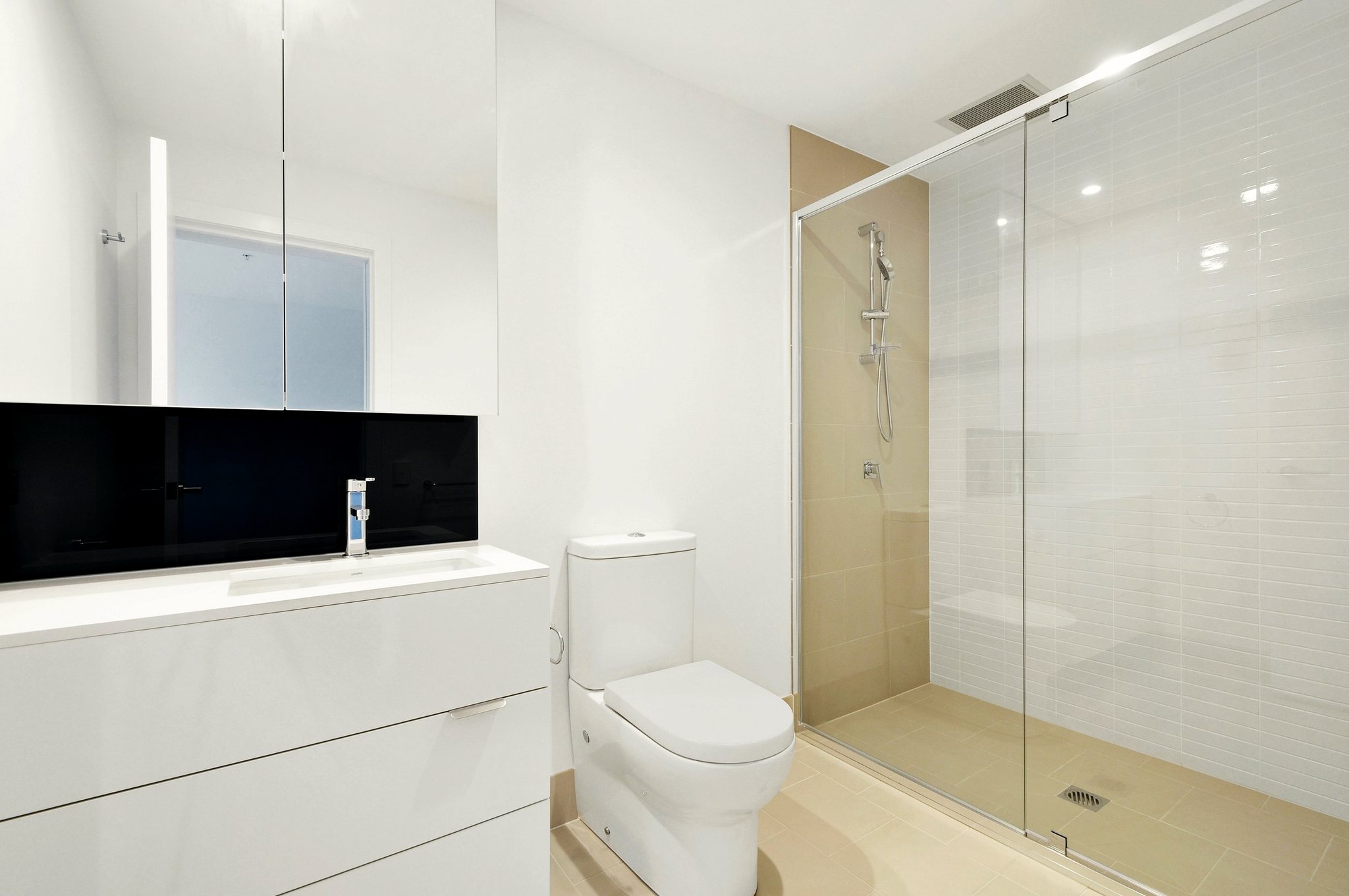 Bagno bianco con doccia in vetro e mobile sospeso